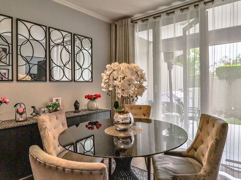 A well-maintained dining area featuring elegant cove molding and large sliding glass doors that provide seamless access to the outdoor patio space.