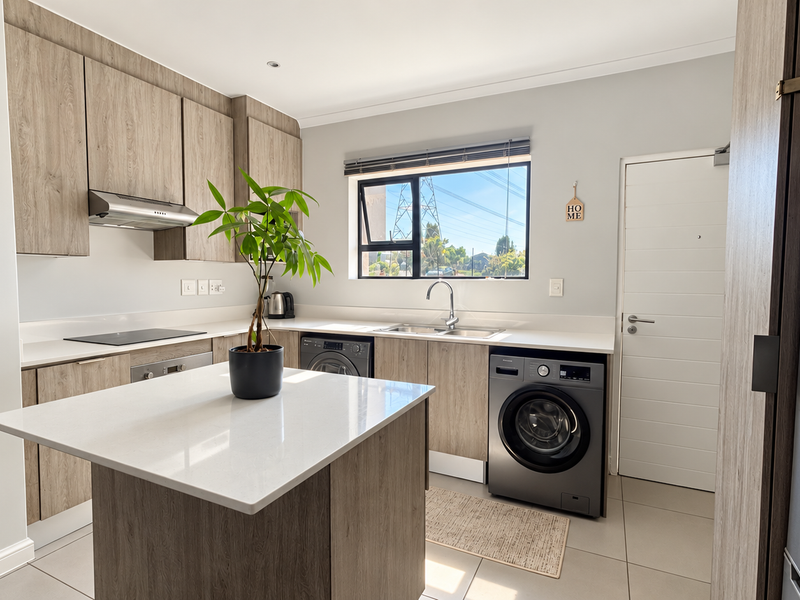 Modern kitchen featuring wood-grain cabinetry, stone countertops, a central island, and integrated appliances, offering a clean and functional workspace.