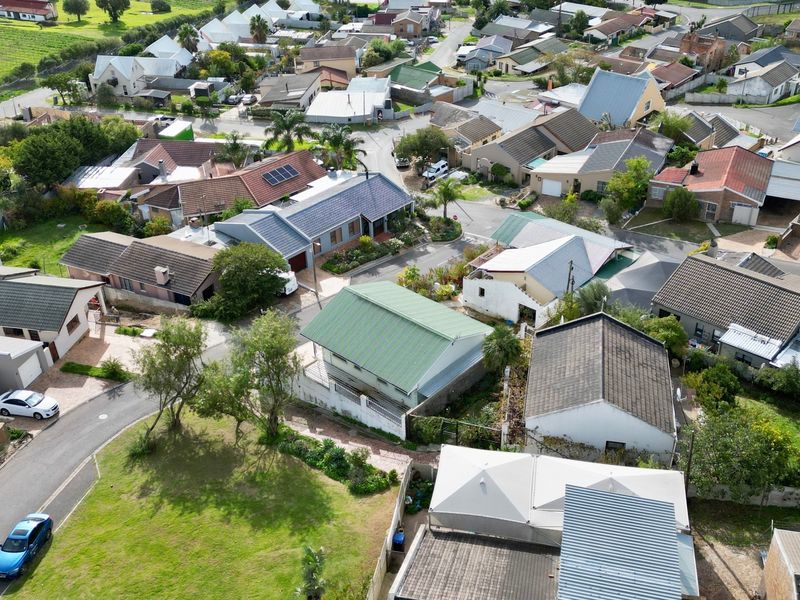 An aerial view of a residential neighbourhood showcasing the layout of houses, roof structures, and surrounding street infrastructure.
