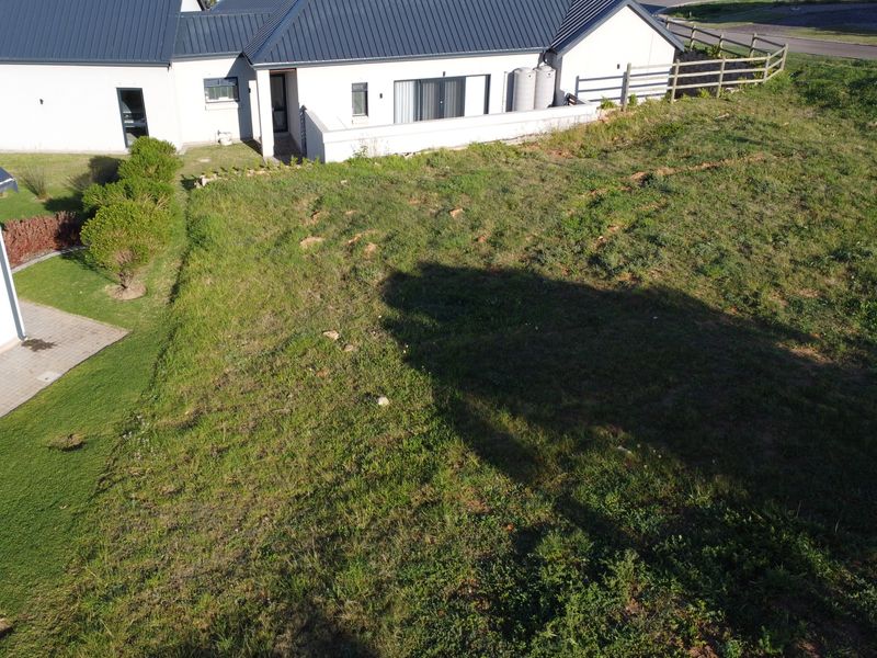 Aerial view of a residential property showing the building structure, surrounding lawn, and boundary fencing.