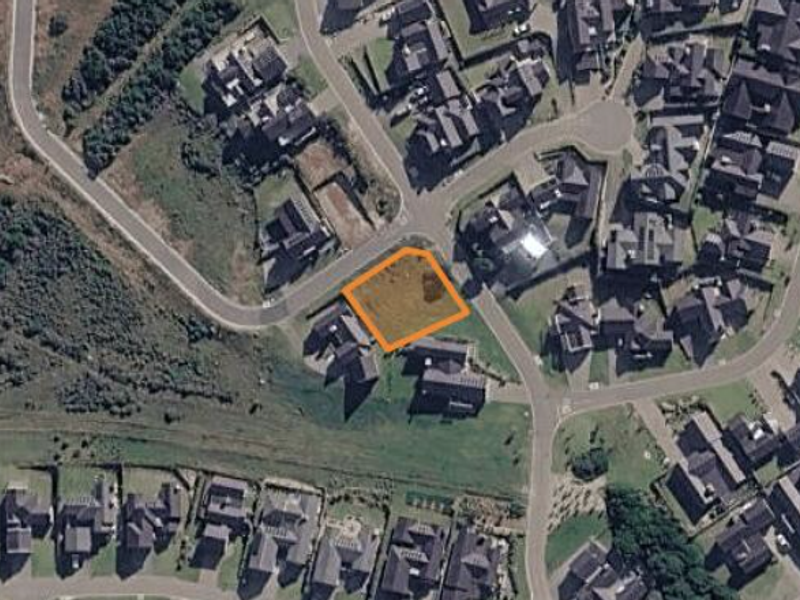 Aerial view of a vacant residential plot situated within an established suburban neighborhood.