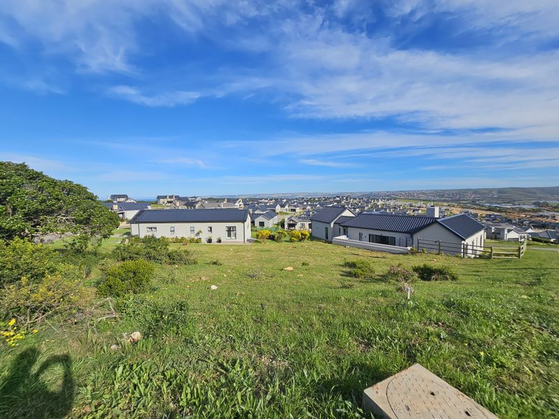 An elevated view overlooking a residential estate with modern homes and surrounding landscape.