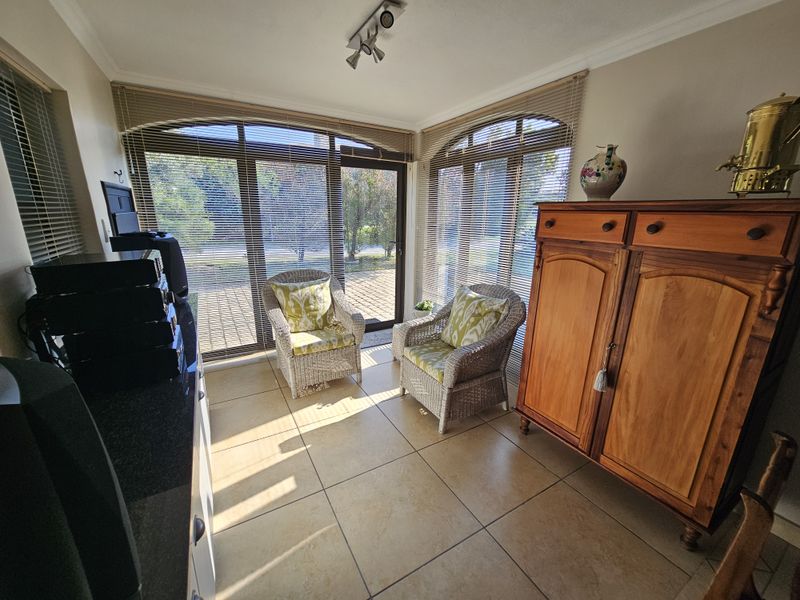 A bright living area featuring large arch-top sliding glass doors, tiled flooring, and modern track lighting, offering a pleasant view of the outdoor space.
