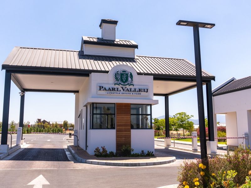 The main entrance gatehouse of Paarl Vallei Lifestyle Estate and Farm, featuring modern architecture, security boom gates, and paved access roads.