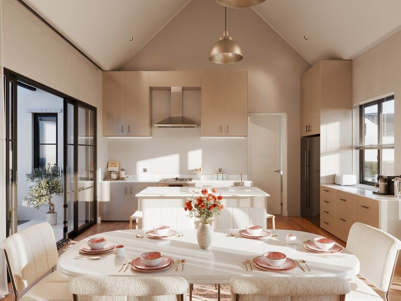 A bright, modern open-plan kitchen and dining area featuring a vaulted ceiling, sleek cabinetry, a central island, and large sliding doors leading outdoors.