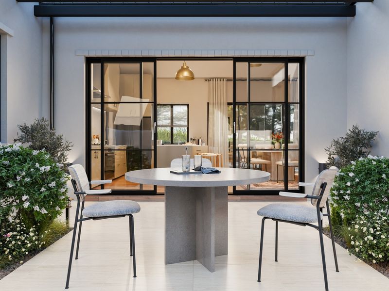 A modern, well-maintained covered patio area featuring tiled flooring and large sliding glass doors that provide seamless access to the interior living space.