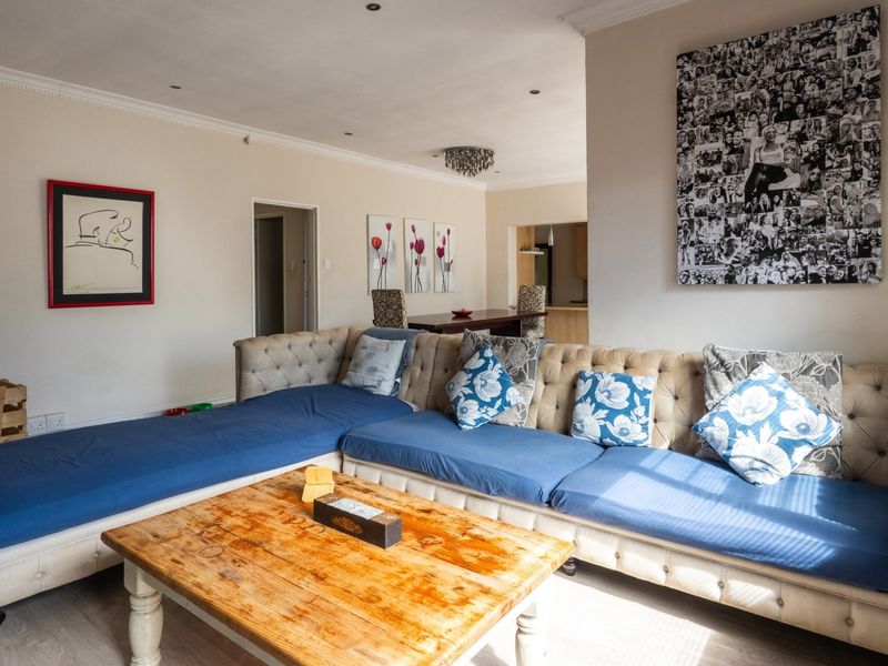 Spacious open-plan living area featuring laminate flooring, recessed downlighting, and coved ceiling details, providing a versatile layout for dining and relaxation.