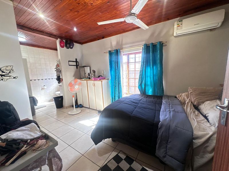 Bedroom featuring tiled flooring, a timber ceiling with a ceiling fan, split-system air conditioning, and an integrated en-suite bathroom.
