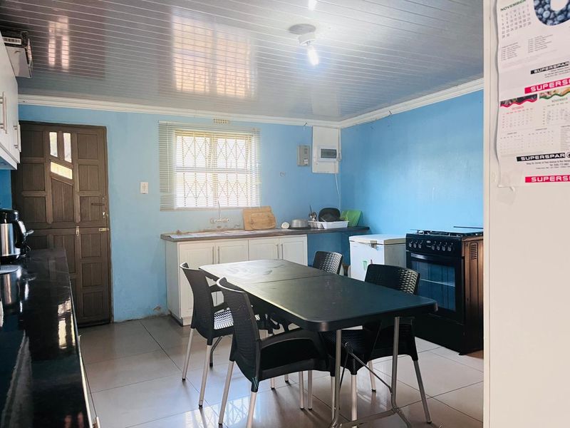 A functional kitchen area featuring tiled flooring, built-in cabinetry, and a sink, with potential for cosmetic updates to enhance the space.