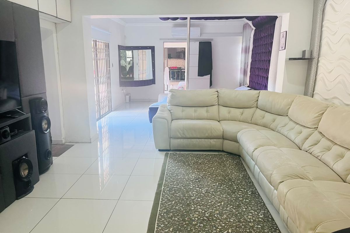 Spacious living area featuring polished tiled flooring, built-in storage, and an air conditioning unit, with an open flow to adjacent living spaces.