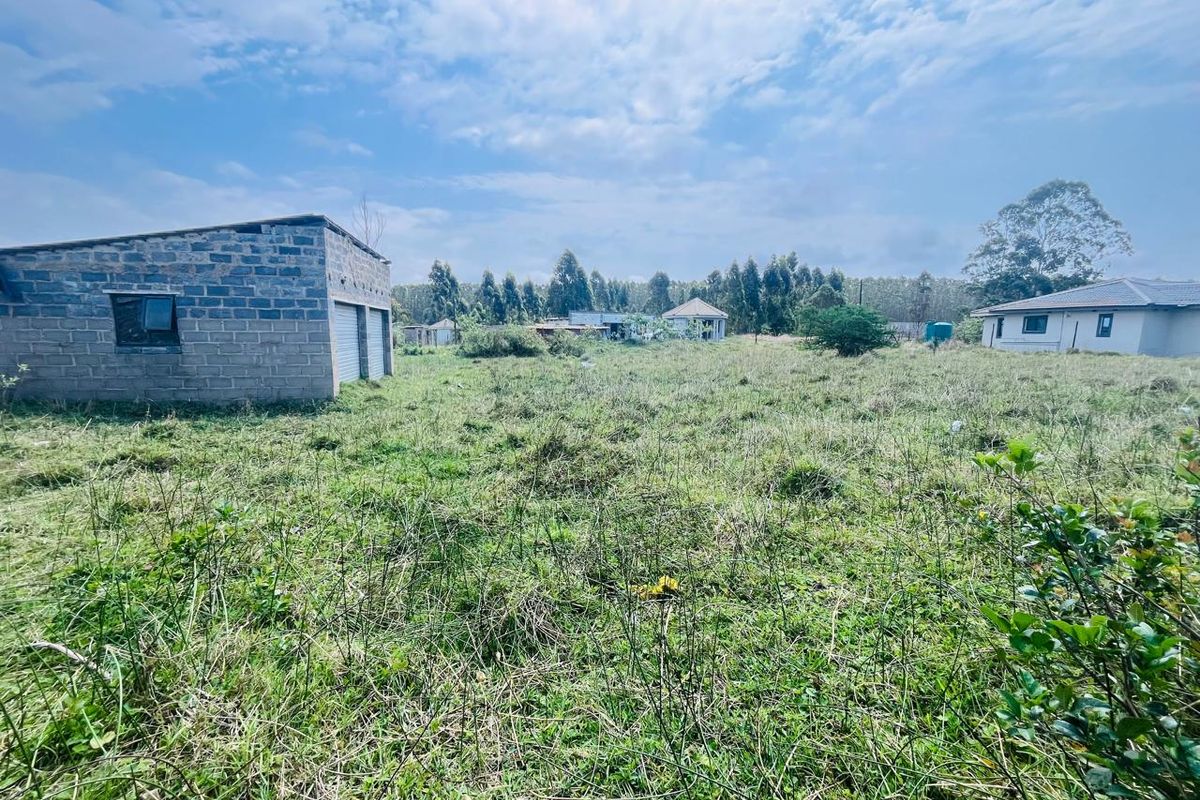 Expansive vacant residential land featuring an existing concrete block outbuilding and natural vegetation, offering potential for future development.
