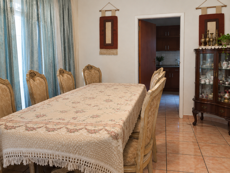 A traditional dining room featuring tiled flooring and a view through to the adjacent kitchen area.