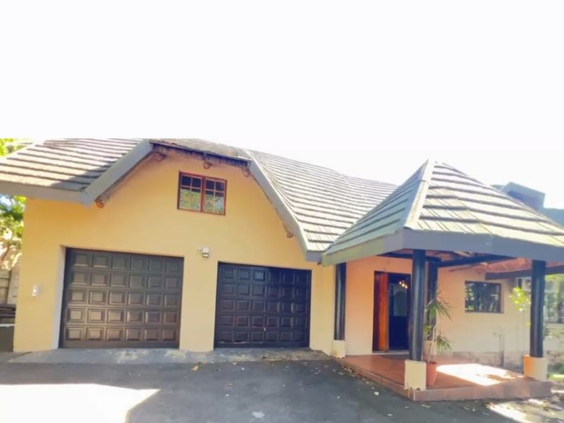 Front elevation of a residential house featuring a double garage, covered entrance porch, and asphalt driveway.