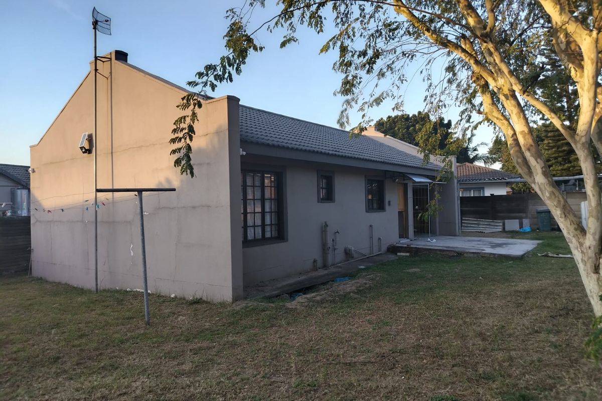 Rear view of the duet property featuring a concrete patio area, tiled roof, and established garden space.