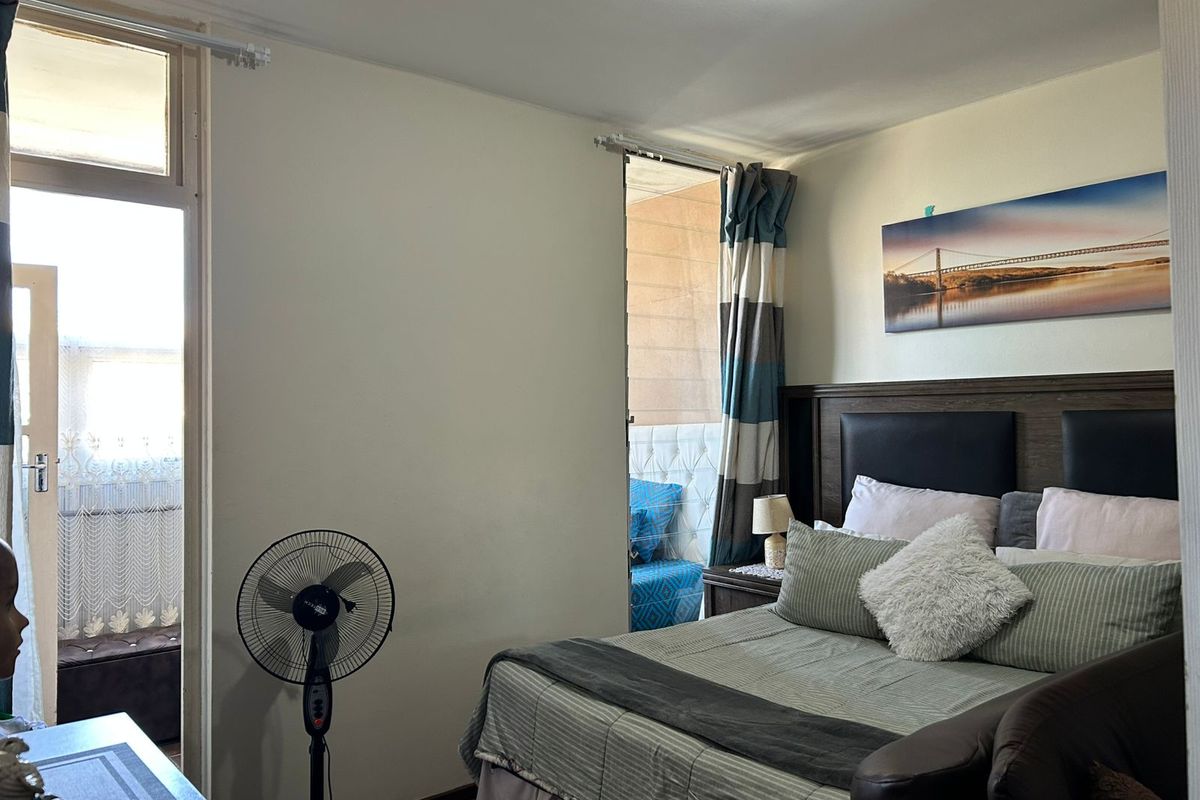 A bedroom featuring direct access to a balcony through a glass door, providing natural light and ventilation.