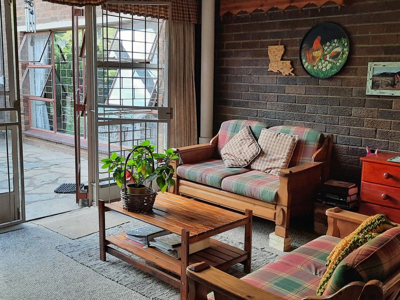 A living room featuring exposed brick walls and large glass sliding doors providing direct access to an outdoor patio area.