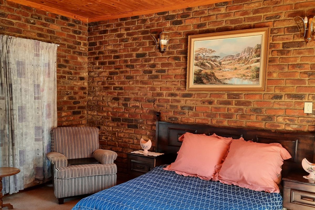 A bedroom featuring exposed face-brick walls and a natural timber ceiling, creating a rustic and warm atmosphere.