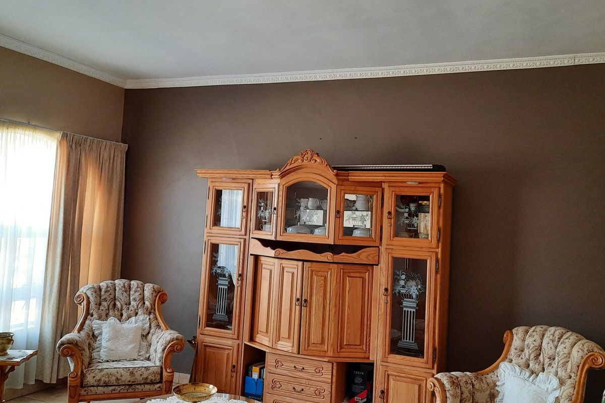 A living room featuring decorative crown molding and large windows with natural light.