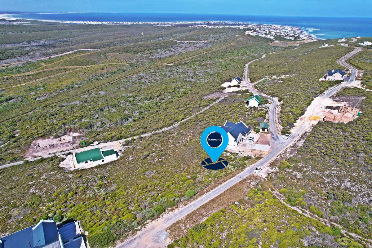 Aerial view of a residential land plot situated in a coastal estate with established access roads and surrounding natural vegetation.