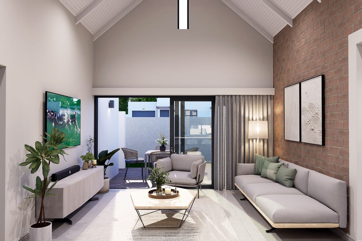 Modern living room featuring a high vaulted ceiling, exposed brick feature wall, and large sliding glass doors opening to an outdoor patio area.
