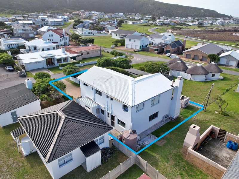 Aerial view of the property showing the main dwelling, roof structure, outdoor braai area, and surrounding residential neighbourhood.