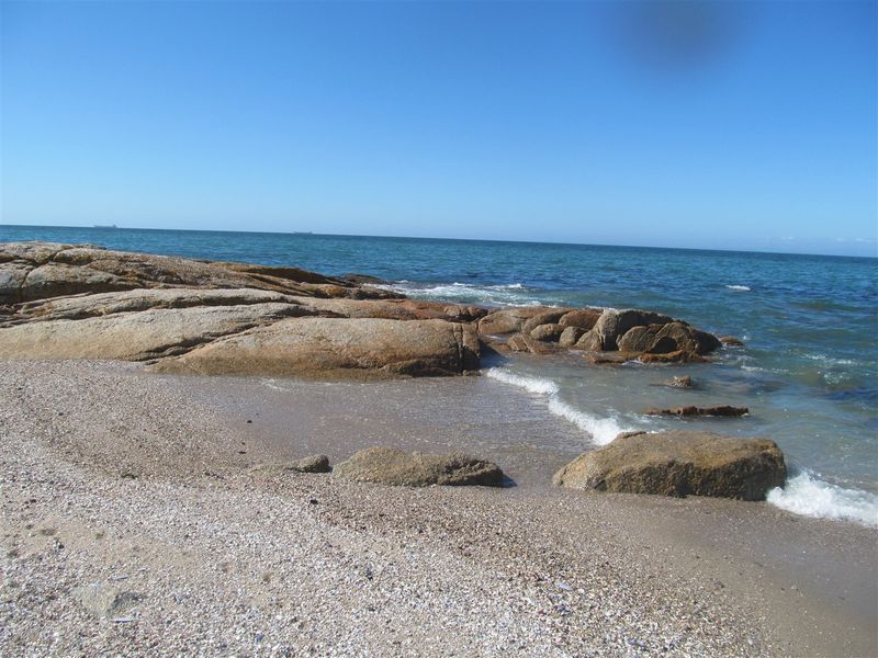 A scenic view of the rocky coastline and ocean, showcasing the natural beauty of the vacant land's surroundings.