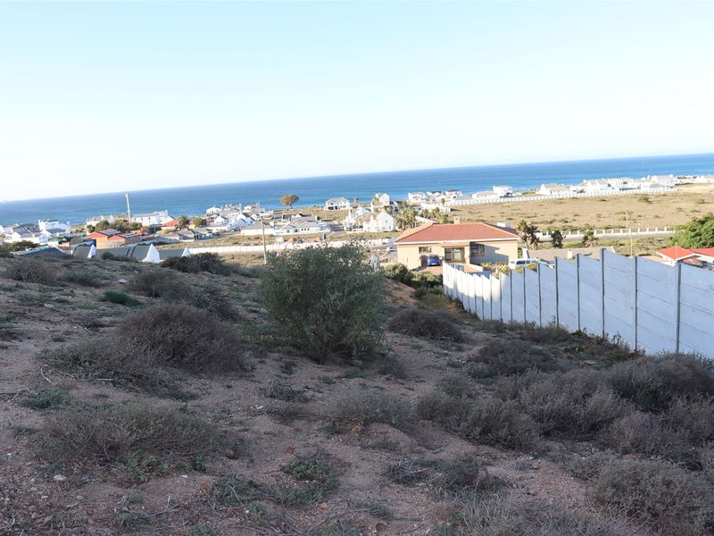 Elevated view overlooking the surrounding residential coastal neighborhood and ocean horizon from the vacant land plot.