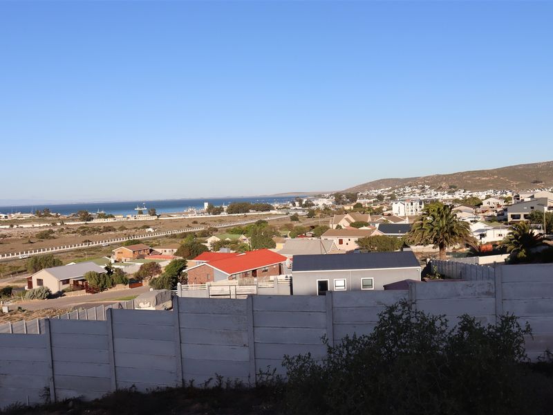 Elevated view overlooking the surrounding residential neighborhood, coastal landscape, and distant sea horizon.