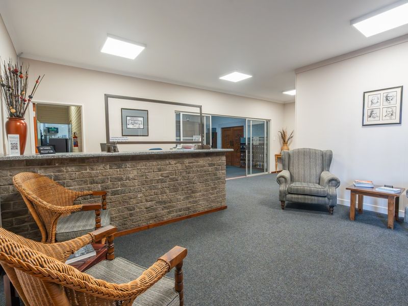 A professional commercial reception area featuring a brick-fronted desk, granite countertop, and integrated LED panel lighting, providing a welcoming entry space.