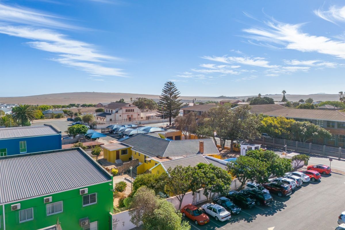 Aerial view of the commercial property showing the building exterior, parking facilities, and surrounding neighborhood landscape.