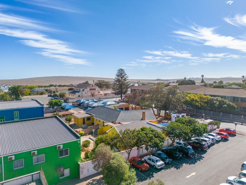 Aerial view of the commercial property showing the building exterior, parking facilities, and surrounding neighborhood landscape.
