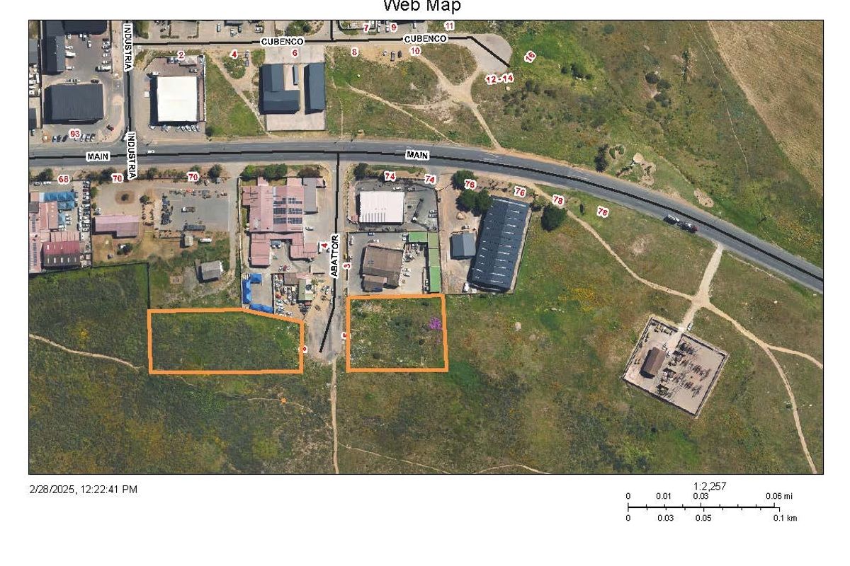 Aerial view of vacant commercial land plots situated within an established industrial area with direct road access.