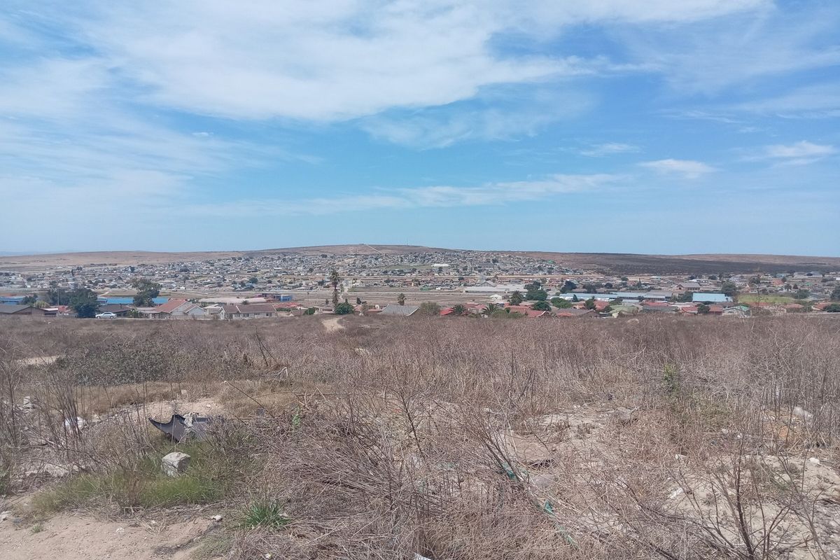 An elevated view overlooking the surrounding landscape and residential neighborhood from the vacant commercial land.