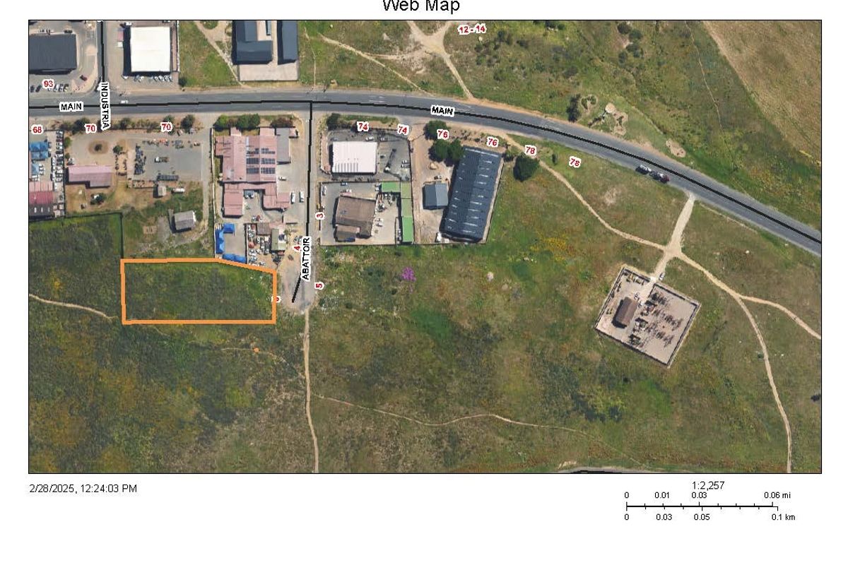 Aerial view of a vacant commercial land parcel with road access, situated in an established industrial area.