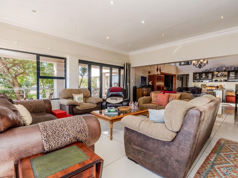 Spacious open-plan living area featuring tiled floors, recessed lighting, and large aluminium sliding doors providing seamless access to the outdoor space.