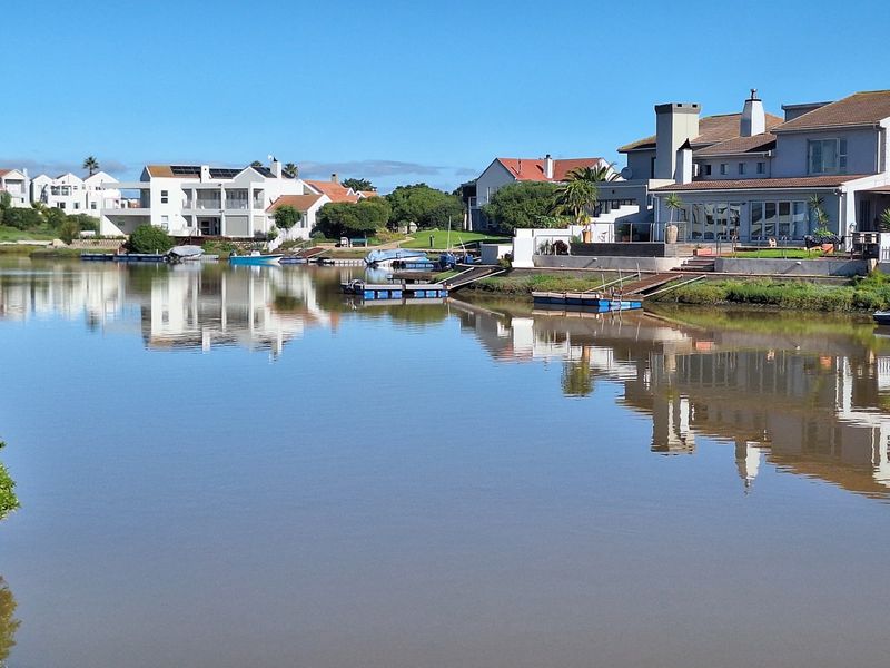 A scenic view of a tranquil waterfront residential estate featuring private jetties and well-maintained homes along the canal.