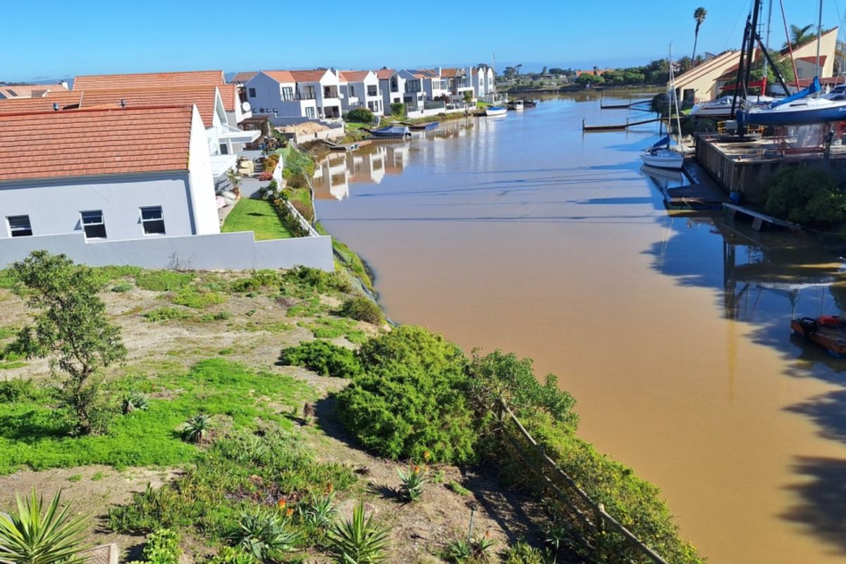 A scenic view of the canal and surrounding residential properties, highlighting the waterfront location and natural landscape.