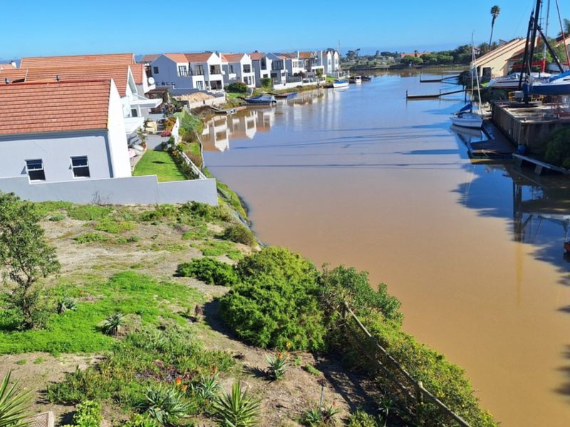 A scenic view of the canal and surrounding residential properties, highlighting the waterfront location and natural landscape.