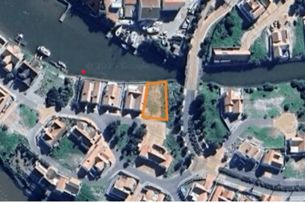 Aerial view of a vacant residential land plot situated in a waterfront estate, highlighting its location and surrounding neighborhood context.