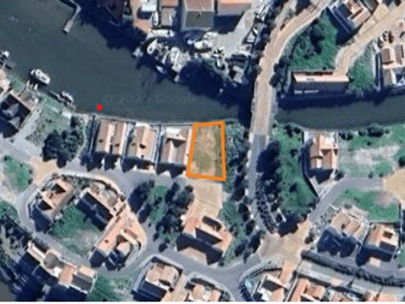 Aerial view of a vacant residential land plot situated in a waterfront estate, highlighting its location and surrounding neighborhood context.
