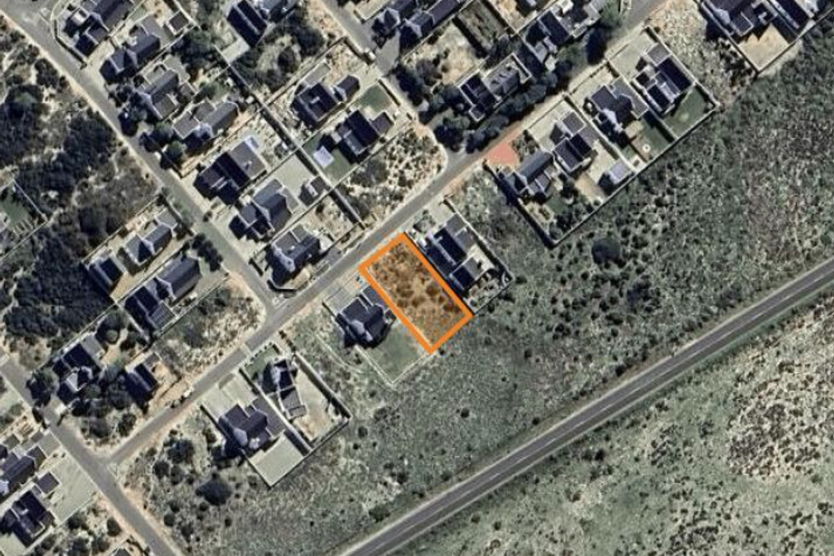 An aerial view of a vacant residential land plot highlighted in an orange border within an established suburban neighborhood.