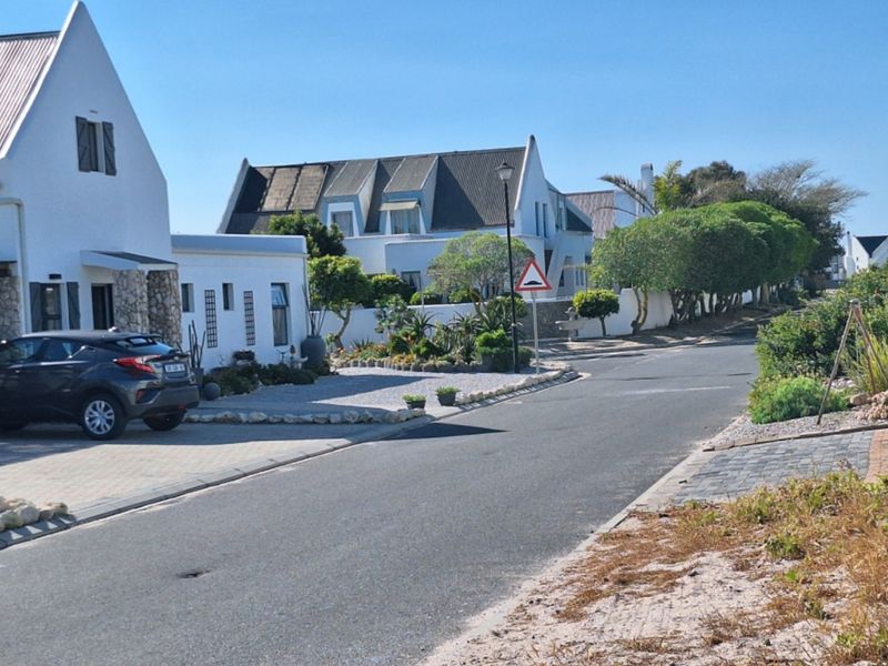 A view of the residential street showing the paved road, surrounding properties, and established landscaping in the neighborhood.