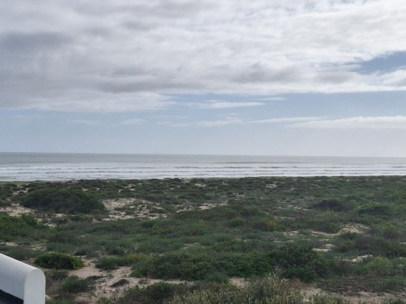 A scenic elevated view overlooking the coastal dunes and the ocean horizon.