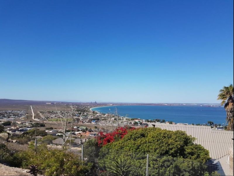 Elevated panoramic view overlooking the coastline, bay, and surrounding residential area.