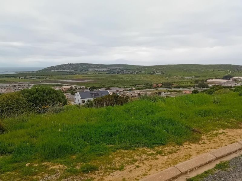 An elevated view overlooking the surrounding landscape, coastal area, and distant residential development.