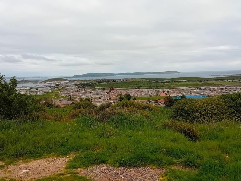 Elevated panoramic view overlooking the surrounding landscape, coastal town, and distant ocean horizon.