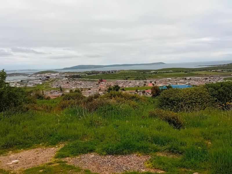 An elevated panoramic view overlooking the surrounding coastal landscape, residential area, and distant bay.
