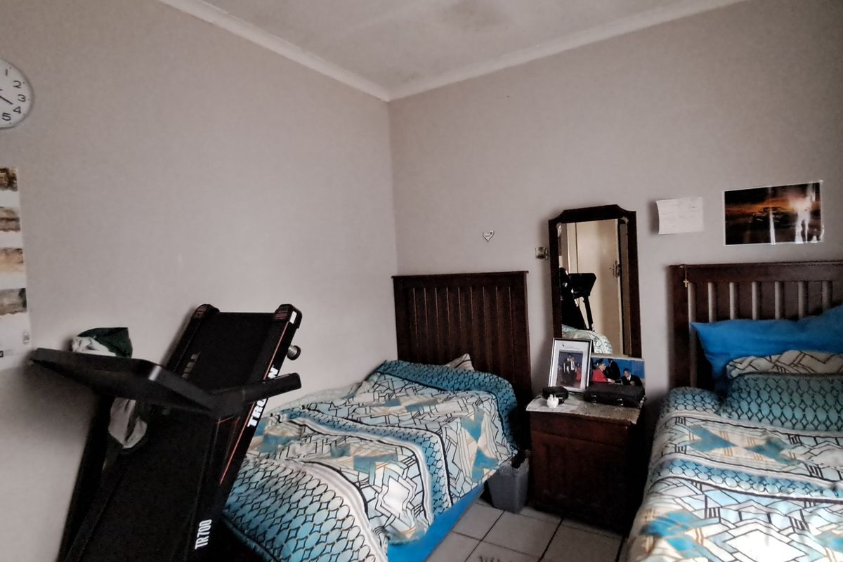 A functional bedroom featuring tiled flooring and built-in headboards, providing a practical space for rest.