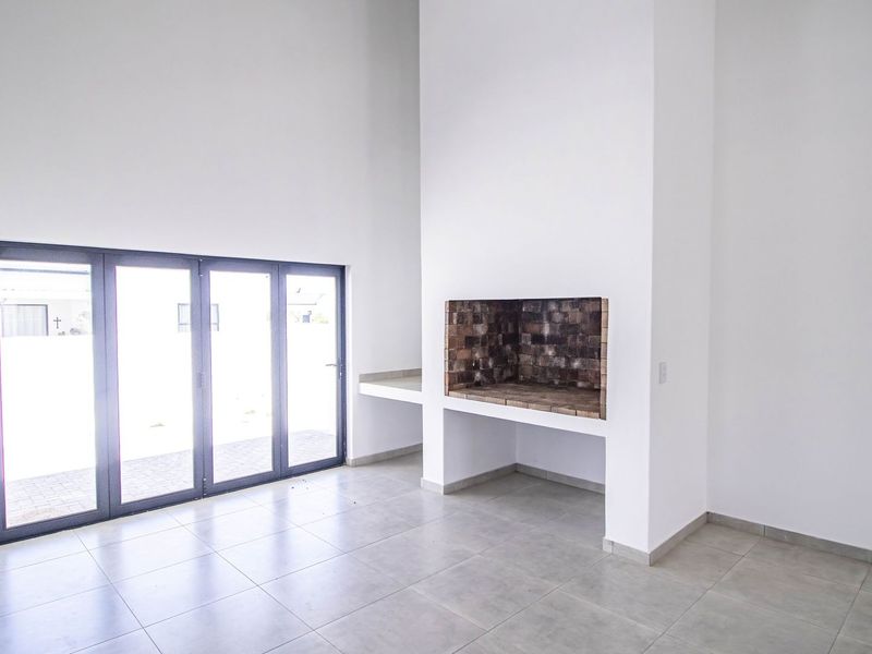Spacious living area featuring a built-in fireplace, tiled flooring, and large bi-fold doors providing seamless access to the outdoor space.