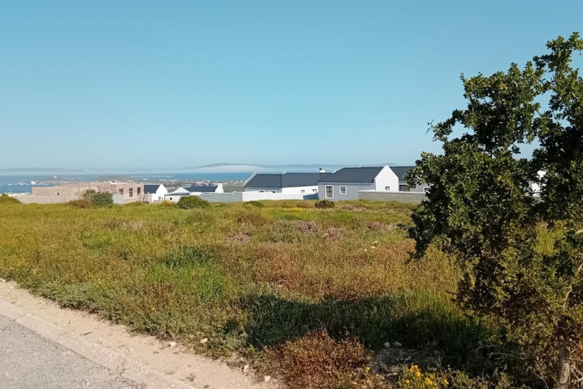 A scenic view overlooking a residential neighborhood with coastal landscape and distant ocean horizon.